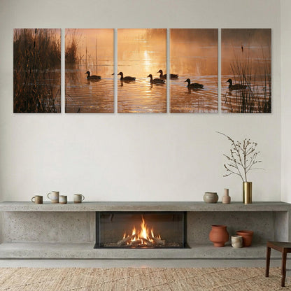 A cozy living room with a fireplace, a coffee table, and a vase of flowers. Above the fireplace, there is a collage of five pictures depicting ducks swimming in a pond at sunrise.