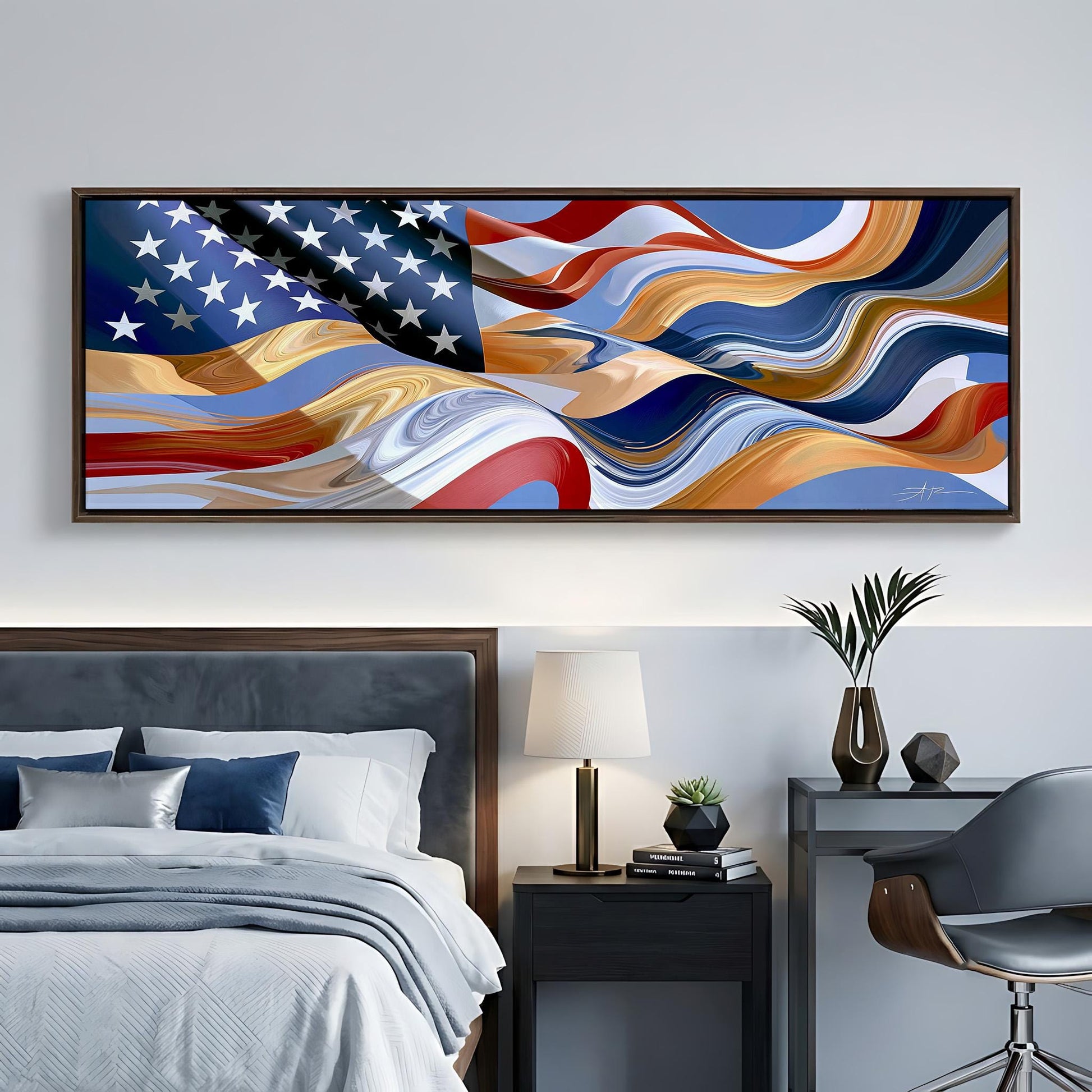 a large, abstract painting of the American flag hanging on a wall above a bed with a gray headboard. The painting has a vibrant, swirling design that resembles the colors and patterns of the flag. The room also includes a nightstand with a lamp, a chair, and some decorative items such as a vase and a plant.