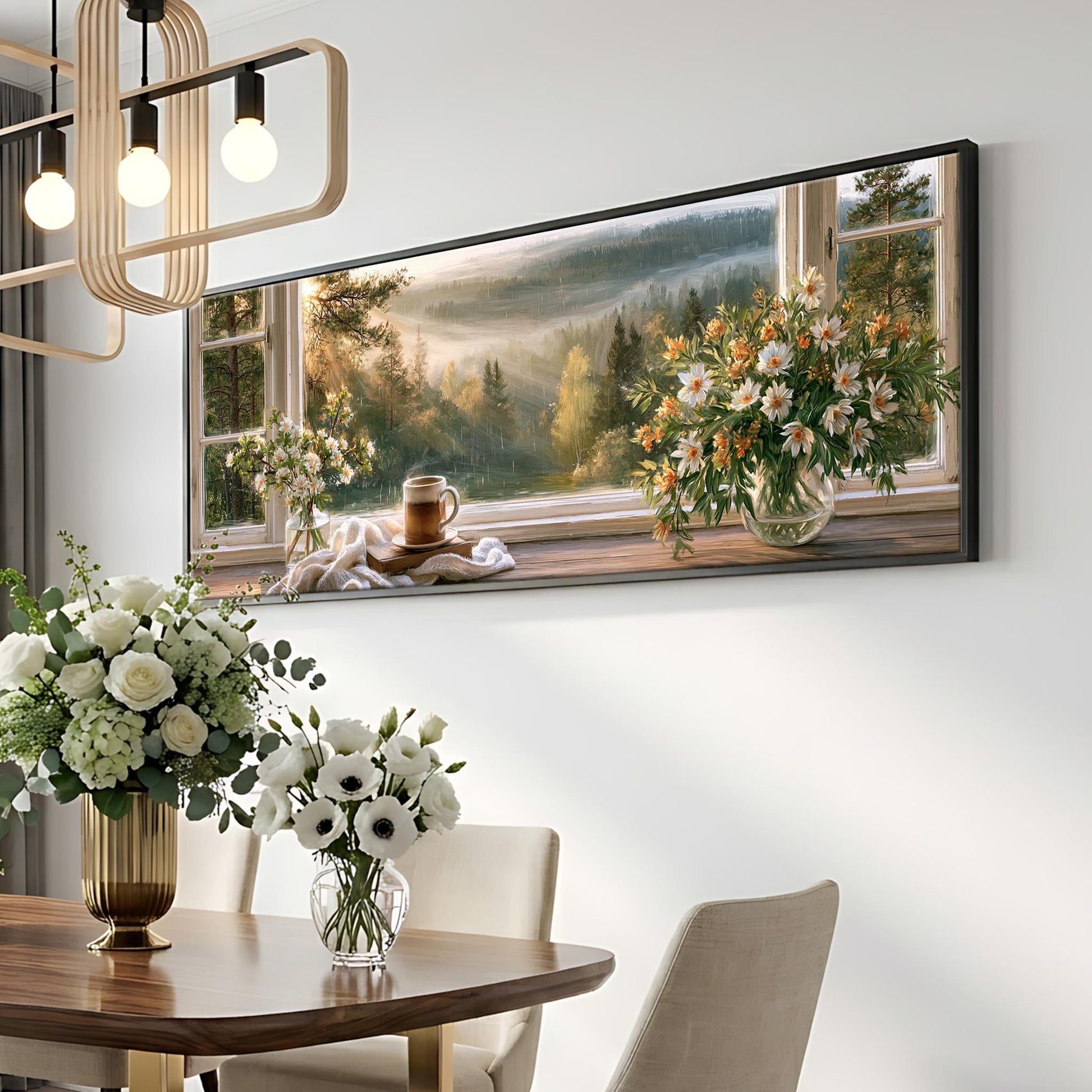 a dining room with a large framed painting of a scenic landscape hanging on the wall above a wooden table. The table is set with a vase of white flowers and a cup, creating a cozy and inviting atmosphere.