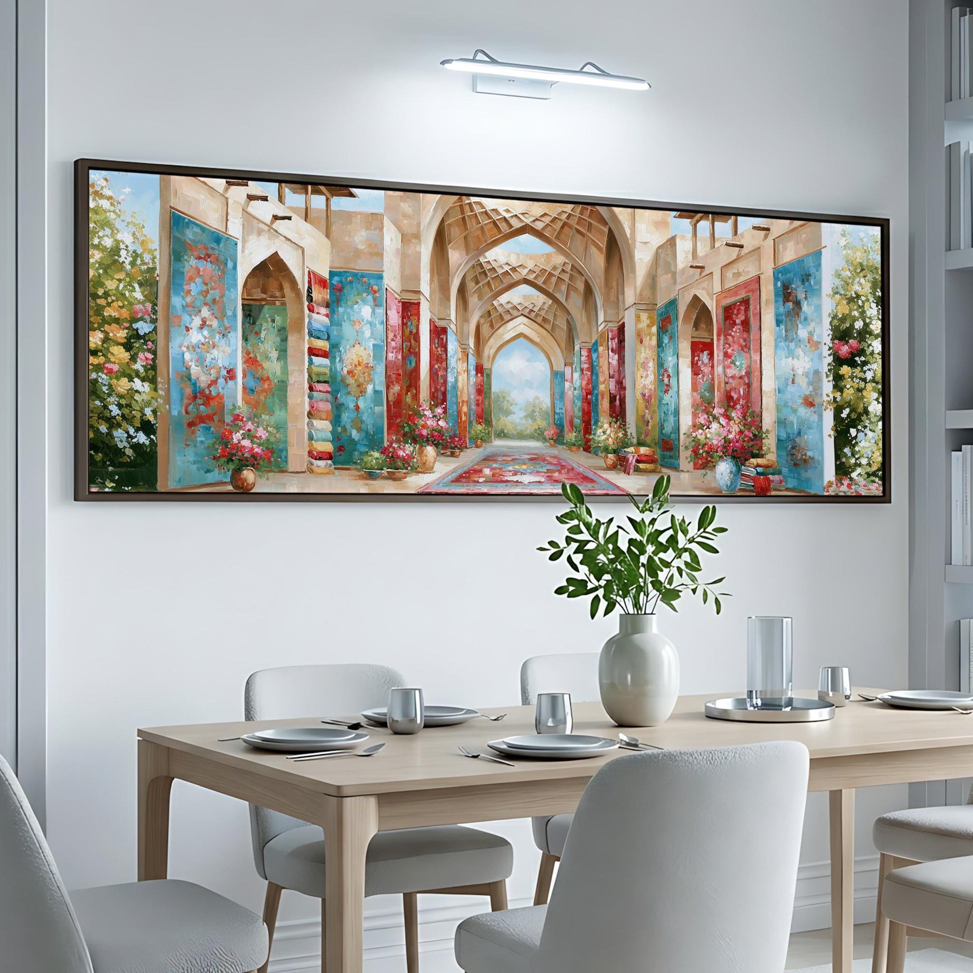 a large, colorful painting of an ornate, arched hallway with floral decorations hanging from the walls. The painting is displayed on a white wall above a dining table set with plates, silverware, and a vase of flowers.