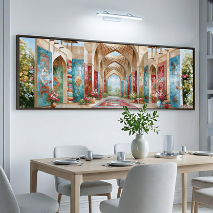 a large, colorful painting of an ornate, arched hallway with floral decorations hanging from the walls. The painting is displayed on a white wall above a dining table set with plates, silverware, and a vase of flowers.