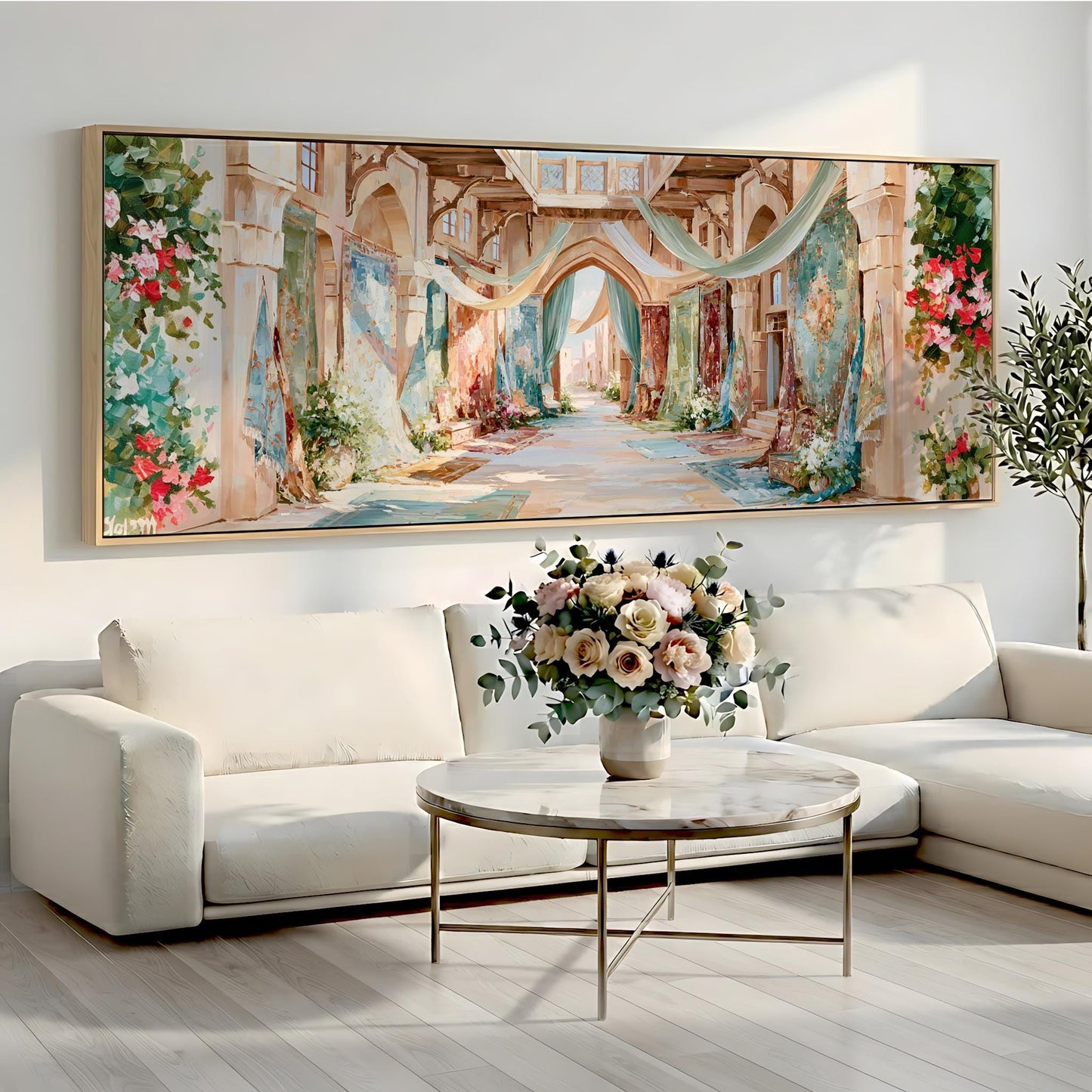 a large, colorful painting of a hallway with arches and flowers hanging on the wall above a white sofa and a round coffee table with a vase of flowers.