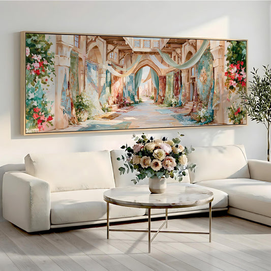 a large, colorful painting of a hallway with arches and flowers hanging on the wall above a white sofa and a round coffee table with a vase of flowers.