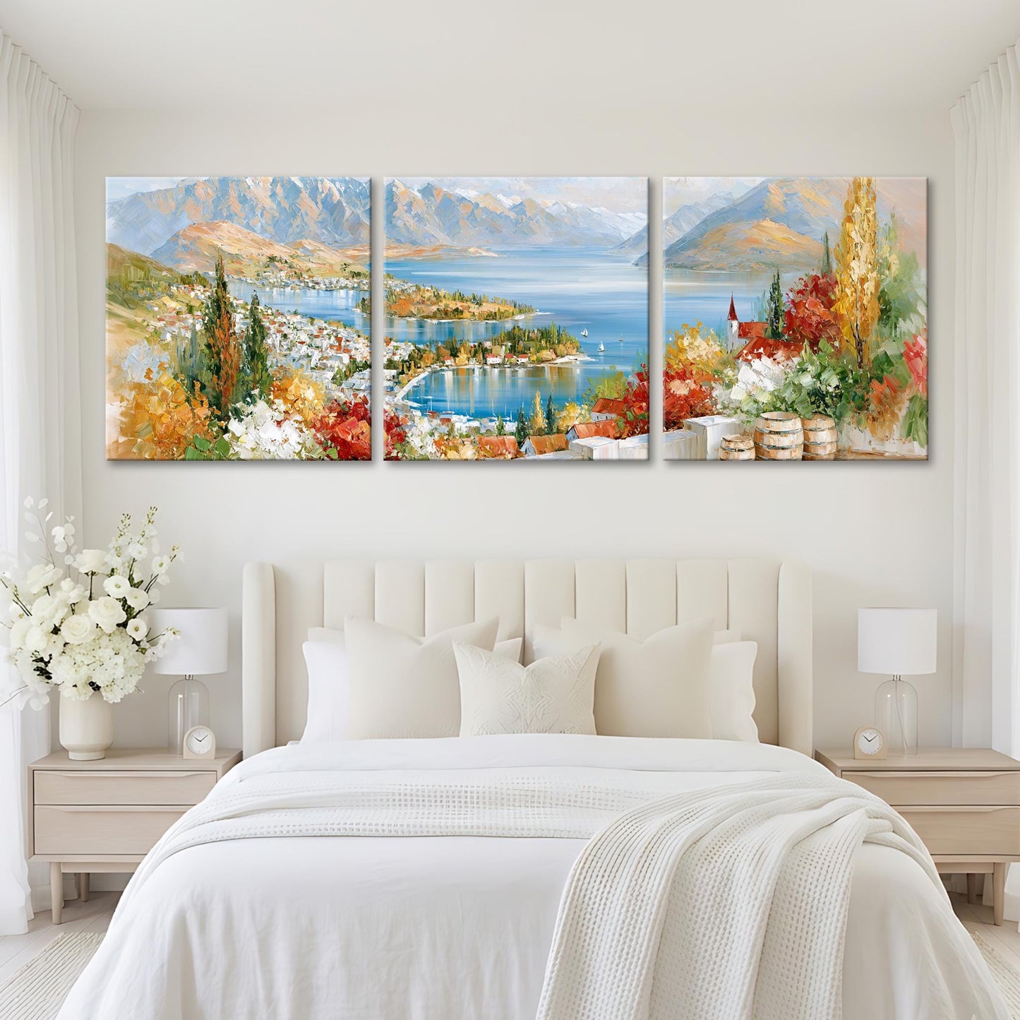 a large, three-panel landscape painting hanging on a white wall above a bed with white bedding.