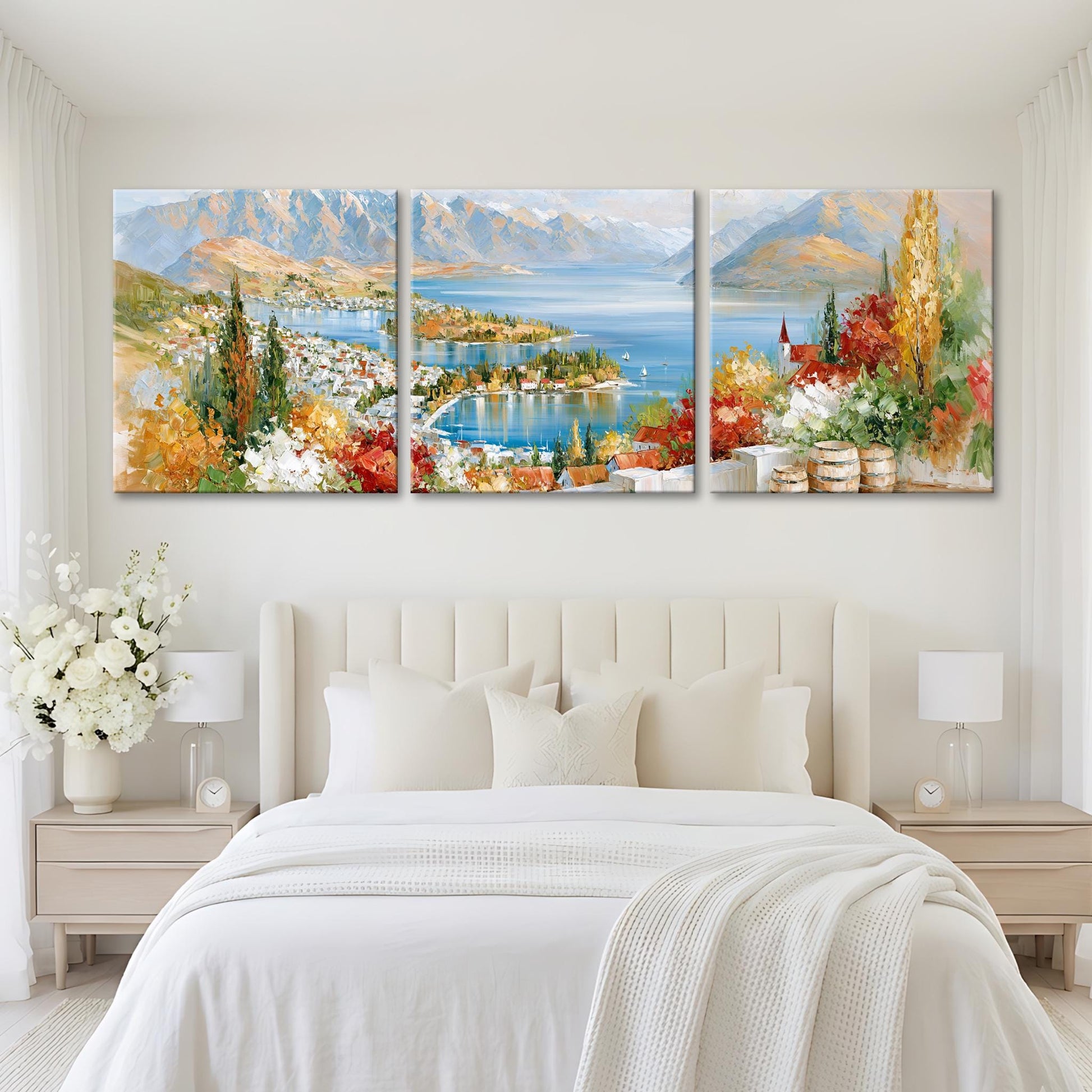 a large, three-panel landscape painting hanging on a white wall above a bed with white bedding.