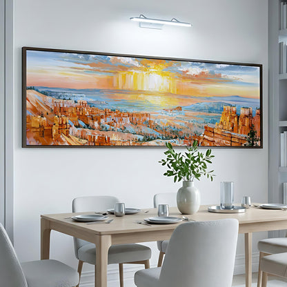 a large, colorful painting of a desert landscape hanging on a wall above a dining table with white chairs.