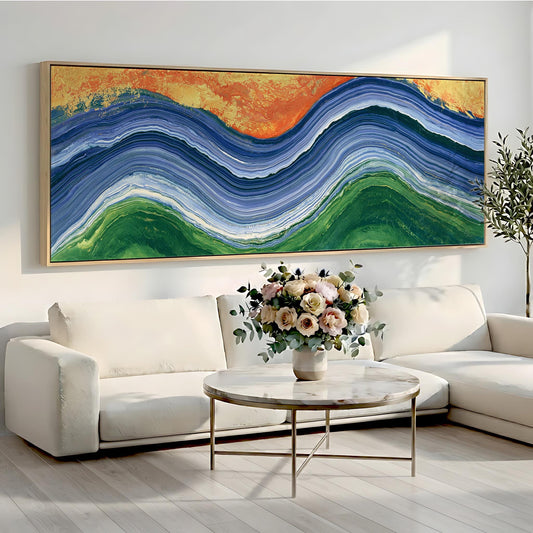 a large abstract painting hanging on a white wall above a white sofa and a round coffee table with a vase of flowers.