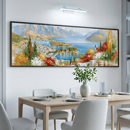 a large, colorful painting of a scenic landscape hanging on a wall above a dining table with white chairs.