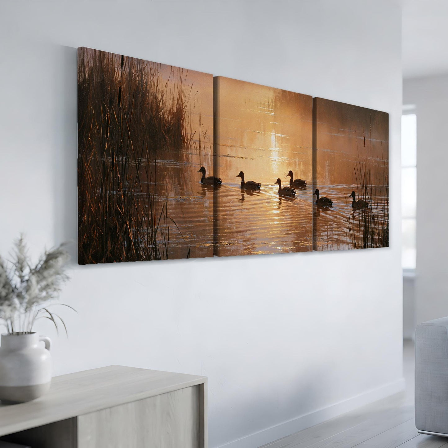 a serene scene of ducks swimming on a calm lake at sunset, with the warm orange and yellow hues of the sky reflected on the water's surface.