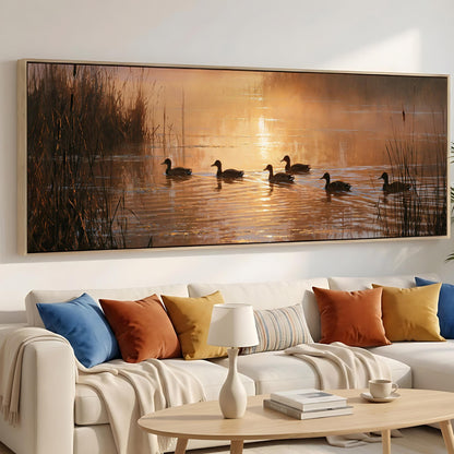 a large painting of ducks swimming on a lake, with a warm sunset in the background.