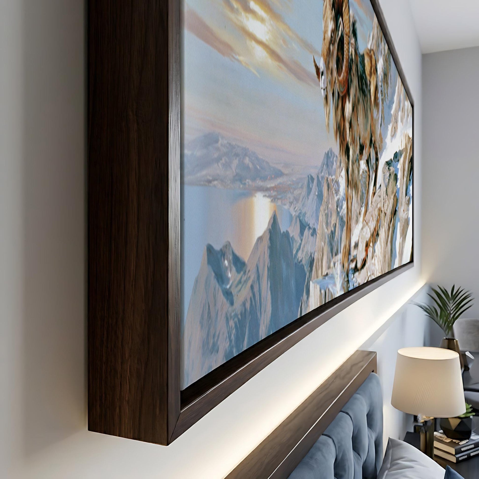a large, framed painting depicting a mountainous landscape with a sunset sky.