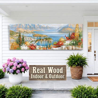 a large wooden sign that reads "Real Wood Indoor & Outdoor" in front of a house with a painting of a scenic landscape above it. The house has a white exterior and a porch with potted plants.