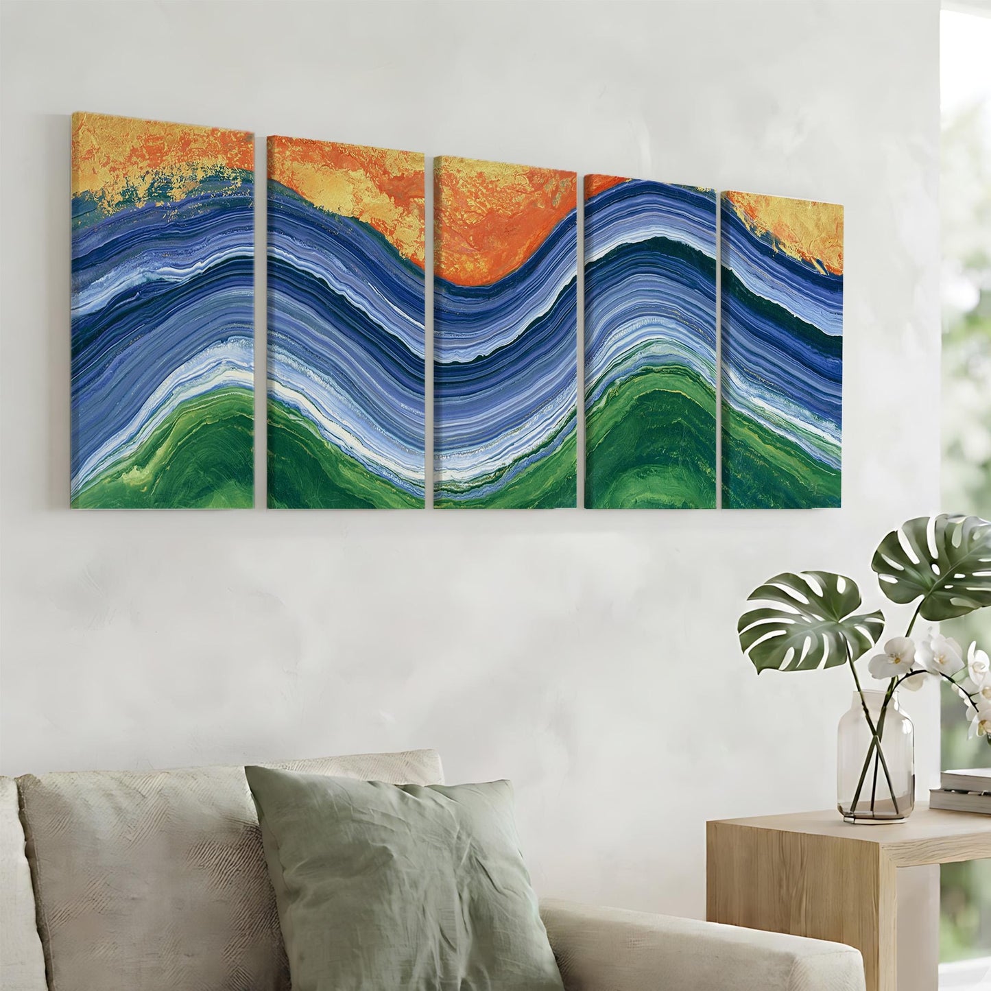 a large abstract painting hanging on a wall, depicting a vibrant and colorful landscape with blue, green, and orange hues. The painting is composed of five distinct panels, each showcasing a different section of the landscape. In the foreground, there is a couch with a green pillow, and a small table with a vase of flowers can be seen nearby.