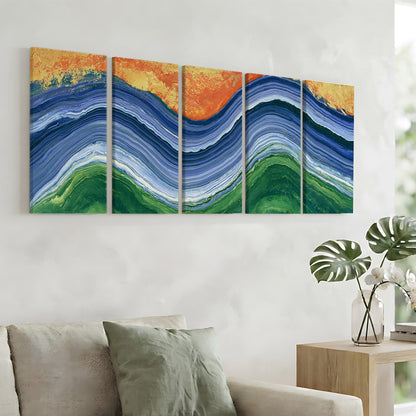 a large abstract painting hanging on a wall, depicting a vibrant and colorful landscape with blue, green, and orange hues. The painting is composed of five distinct panels, each showcasing a different section of the landscape. In the foreground, there is a couch with a green pillow, and a small table with a vase of flowers can be seen nearby.
