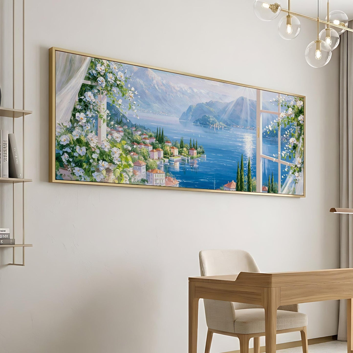 a large, framed painting of a picturesque coastal town with a lake and mountains in the background, hanging on a wall above a wooden desk and chair.