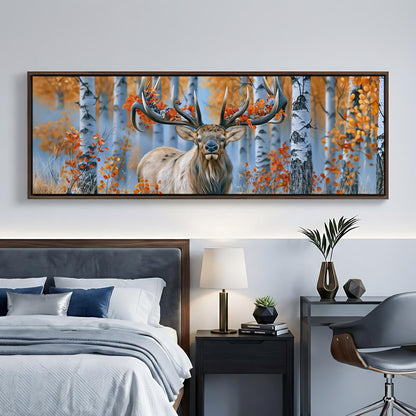 a large framed painting of a deer with antlers in a forest setting, hanging on a wall above a bed with a gray headboard.