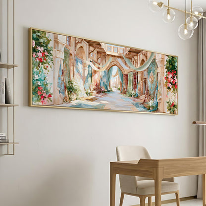 a large, colorful painting of a picturesque alleyway with arches, flowers, and greenery hanging on a wall. In the foreground, there is a wooden desk and chair, suggesting a workspace or study area.