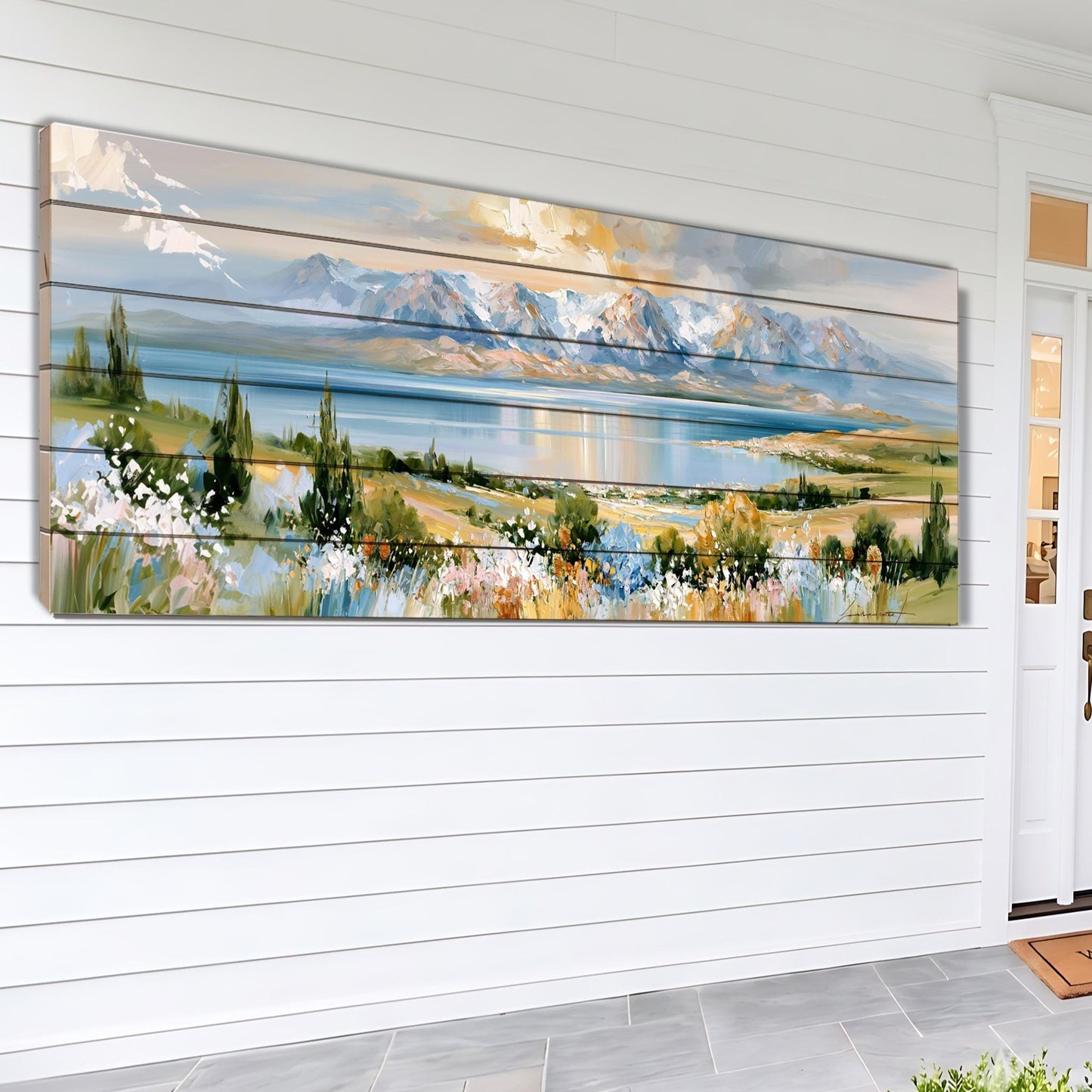 A large, colorful painting depicting a scenic landscape with mountains, a lake, and a field of flowers is displayed on the wall of a white house.