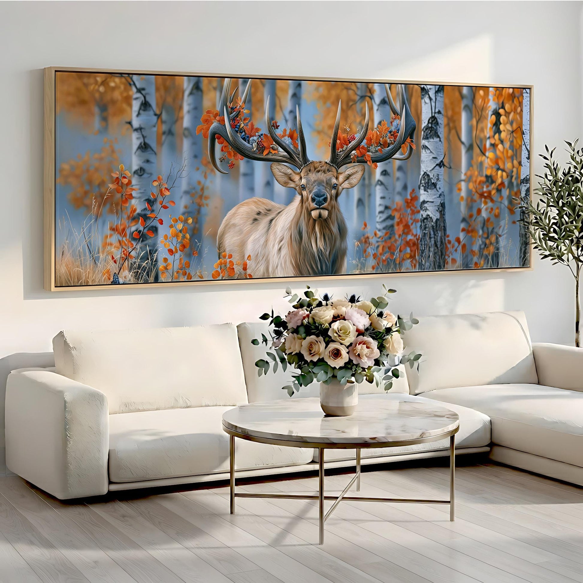 a large painting of a deer with antlers, displayed on a wall above a white sofa and a round coffee table with a vase of flowers.