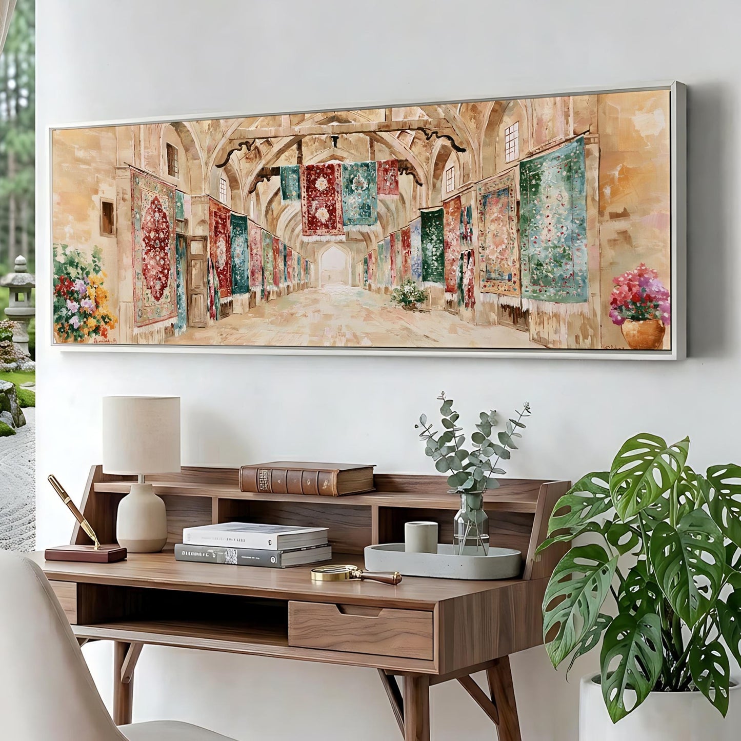 a large painting of a hallway with colorful tapestries hanging on the walls, displayed on a wall above a wooden desk with various items on it.
