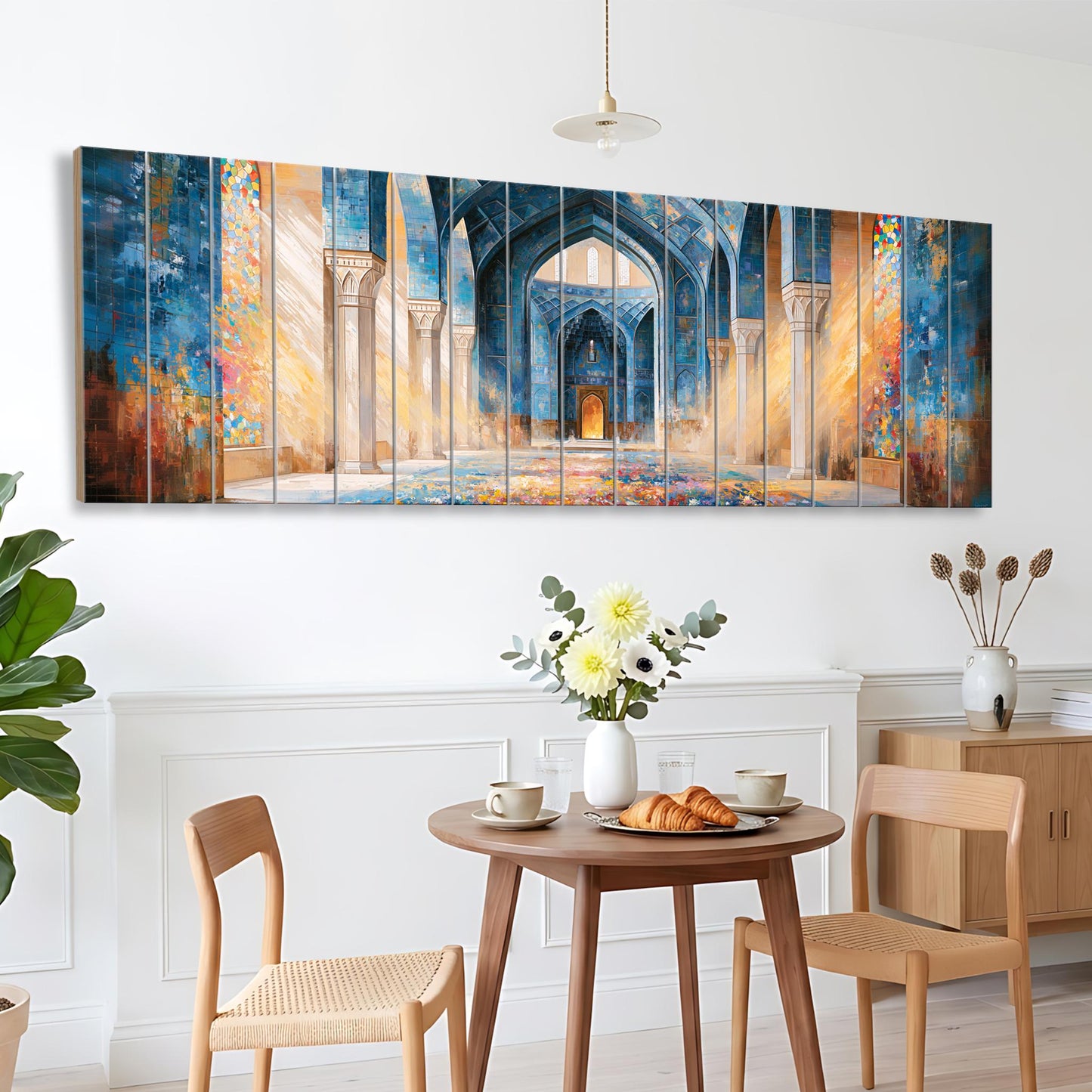 a dining area with a wooden table, two chairs, and a vase of flowers. Above the table, there is a large painting depicting an ornate, colorful archway.