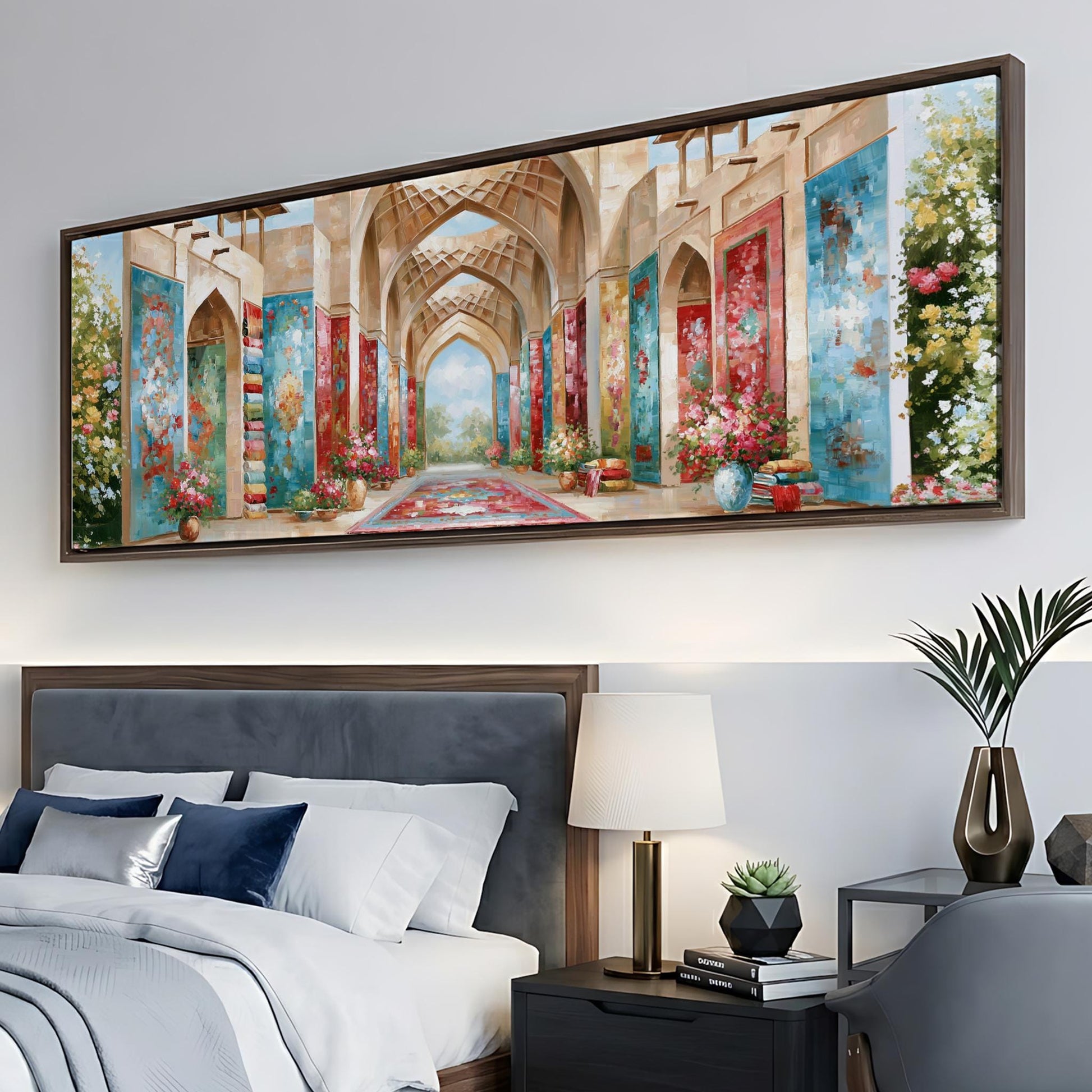 a large, colorful painting of an ornate, arched hallway with floral decorations hanging on the wall above a bed with white linens and blue pillows.