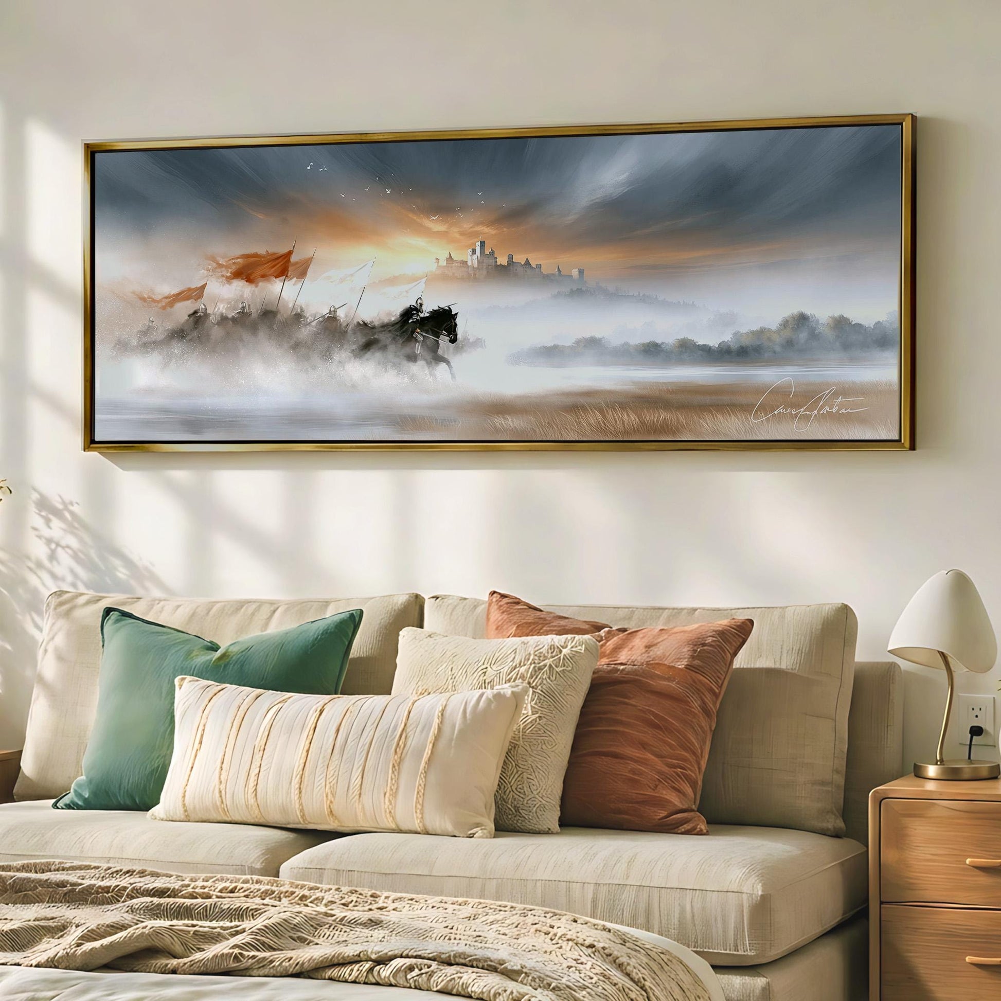 a large painting of a horse-drawn carriage on a foggy landscape, hanging on a wall above a beige sofa with colorful throw pillows.