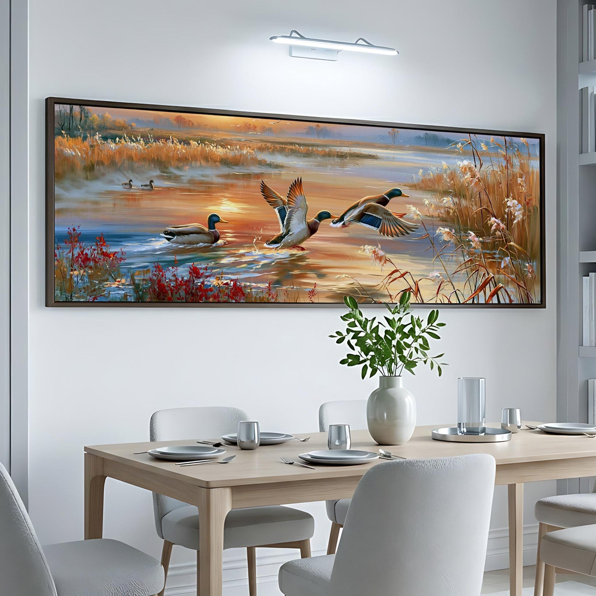 a large painting of ducks on a lake, hanging on a white wall above a dining table with chairs.