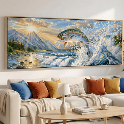 a large painting of a fish leaping out of the water, set against a backdrop of mountains and a sunset. The painting is hung on a wall above a white couch, which is adorned with colorful throw pillows. In the foreground, there is a coffee table with a book and a cup on it.