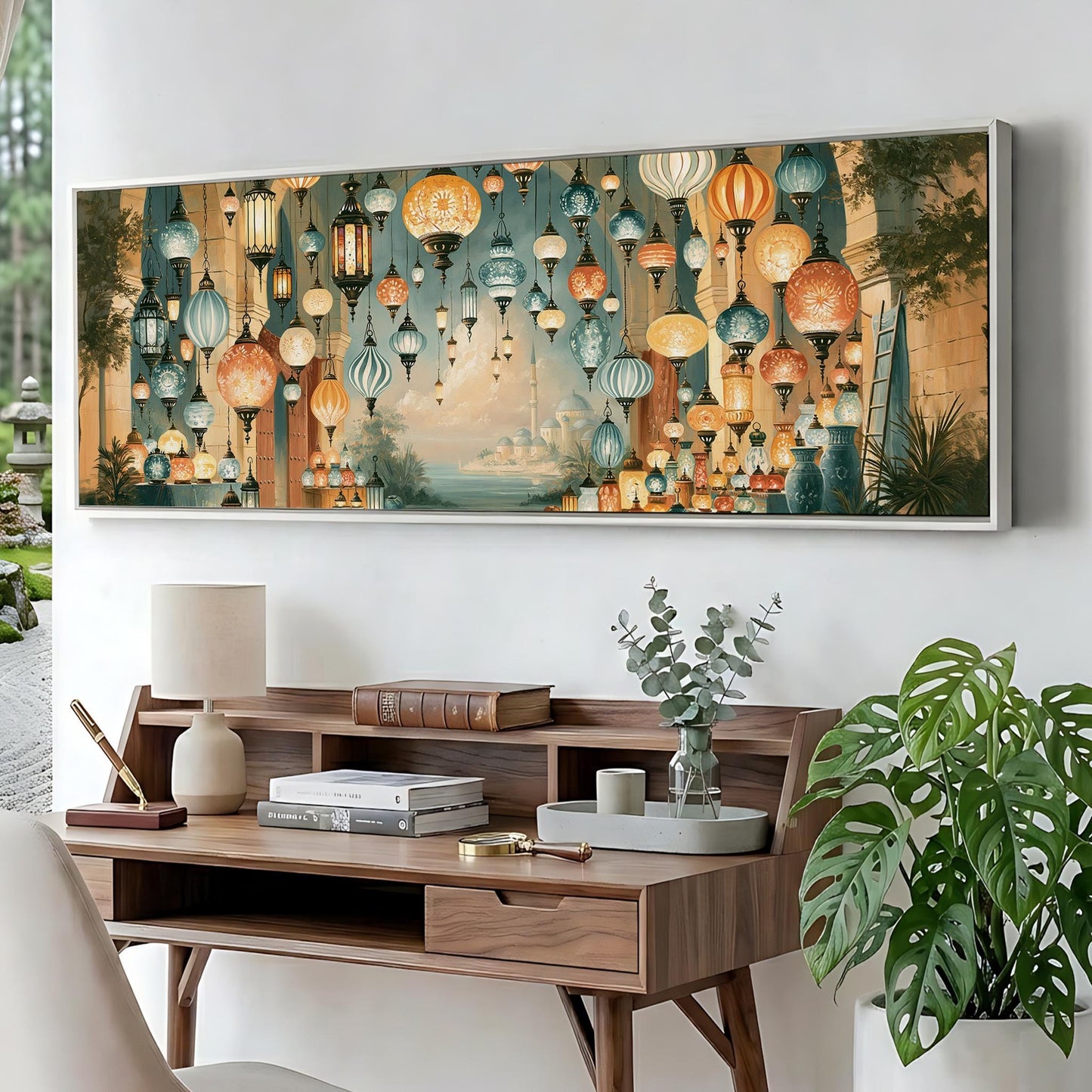 a large, colorful painting of hanging lanterns on a wall above a wooden desk with various items on it, including a lamp, books, and a vase with greenery.