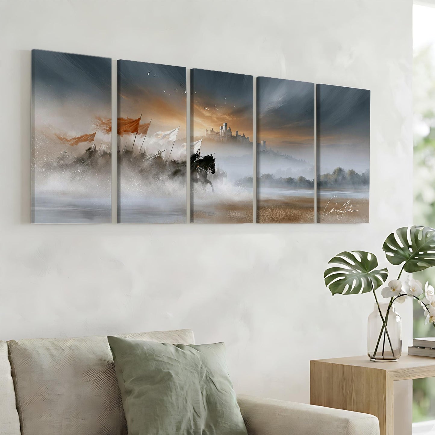 a living room with a large painting of a landscape hanging on the wall. The painting depicts a serene scene with a castle in the distance, surrounded by mist and fog. The room is furnished with a couch and a side table, creating a cozy and inviting atmosphere.