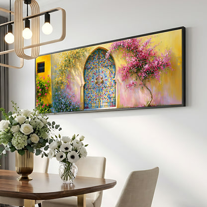 a dining room with a wooden table and chairs, a vase of white flowers, and a large framed painting of a colorful stained glass window above the table.