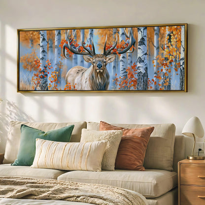 a large framed painting of a deer with antlers in a forest setting, hanging on a wall above a couch with pillows.