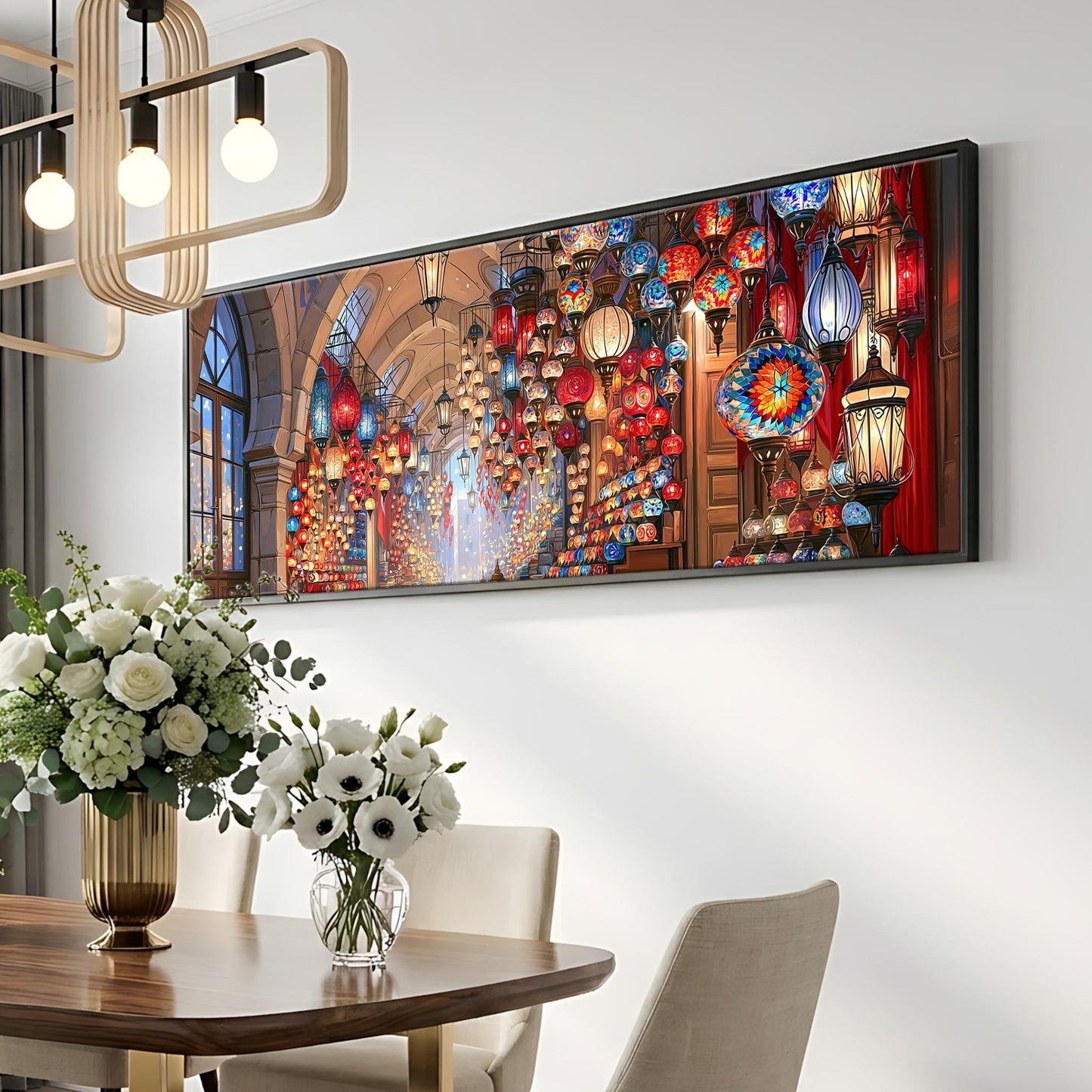 a dining room with a large, colorful painting hanging on the wall above a wooden table. The table is set with a vase of white flowers and a potted plant. The room has a modern and stylish design, with a chandelier hanging from the ceiling and a large window providing natural light.