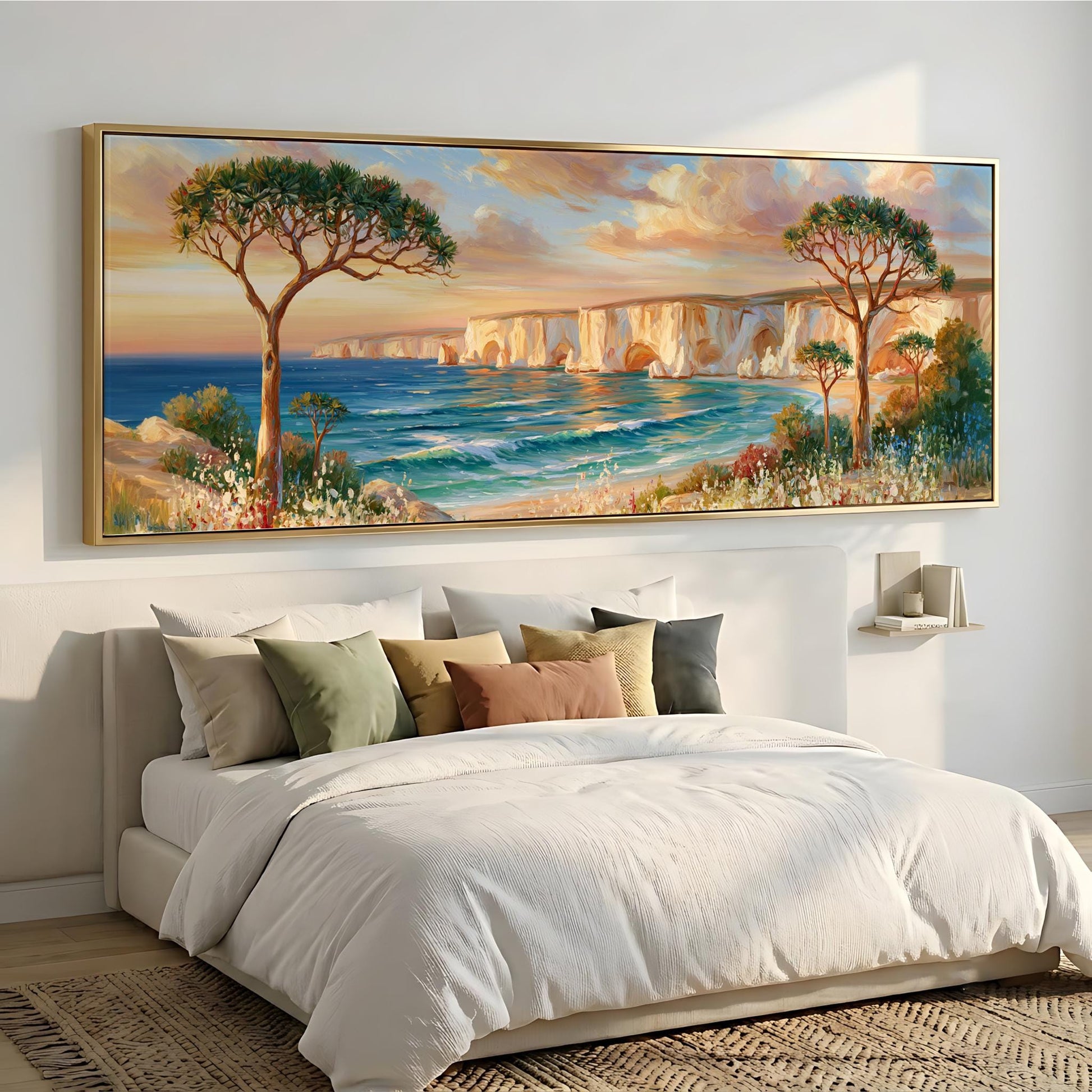 a large painting of a serene coastal landscape hanging on a wall above a bed with white bedding.