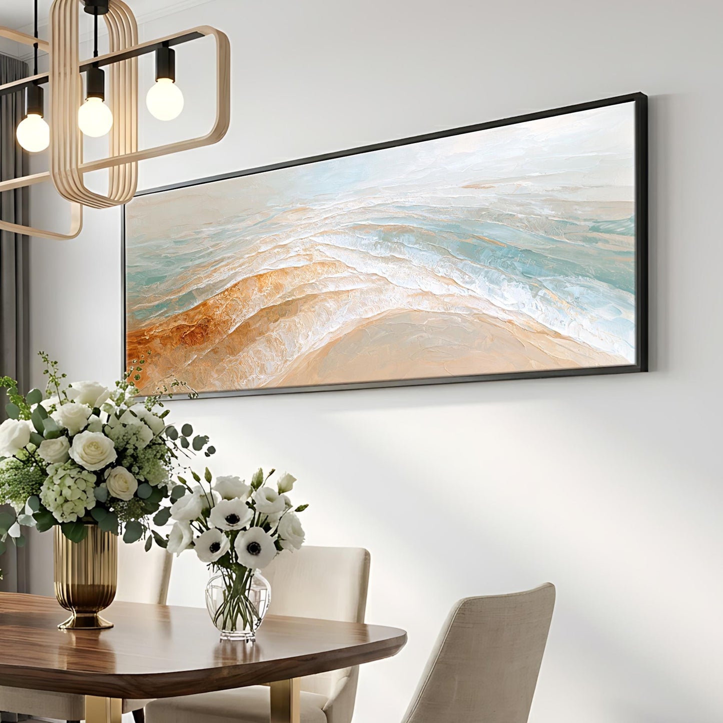 a dining room with a large painting hanging on the wall above a wooden table. The table is set with a vase of white flowers and a potted plant. The room has a modern and elegant design, with a chandelier and a minimalist lighting fixture.