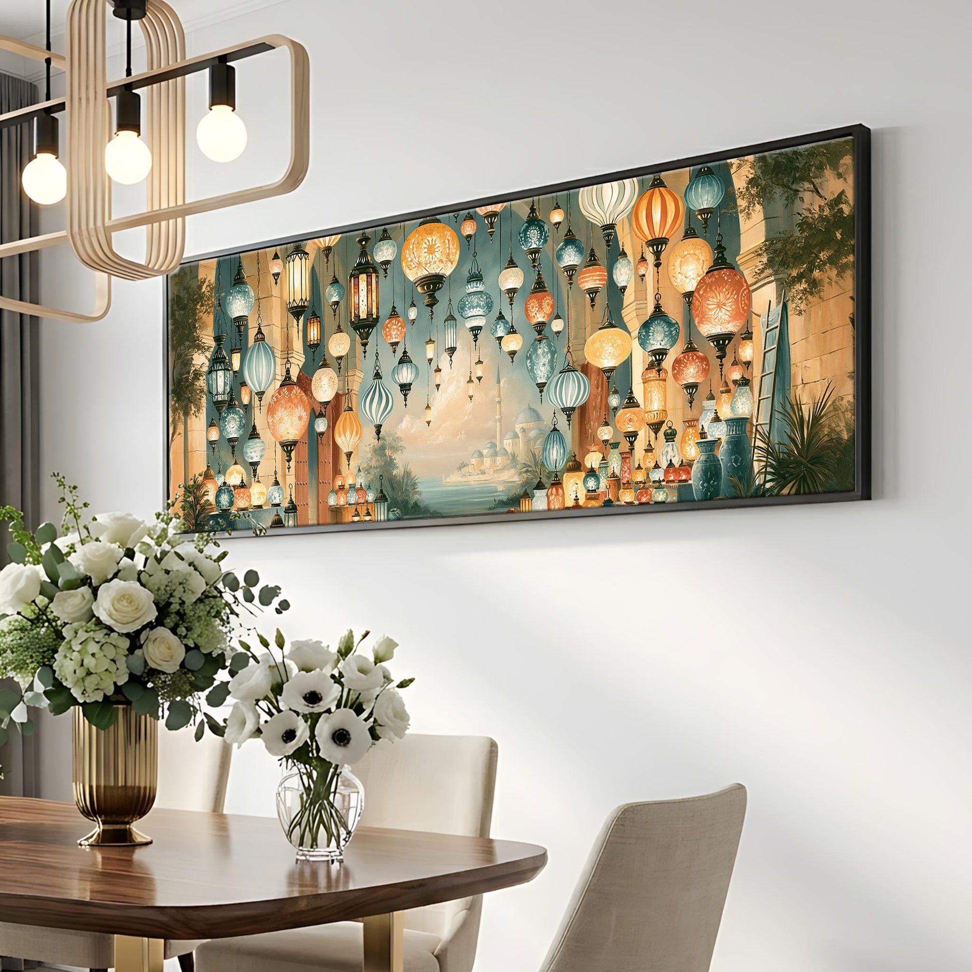 a dining room with a large framed picture hanging on the wall, a vase of white flowers on a table, and a chandelier hanging above the table.