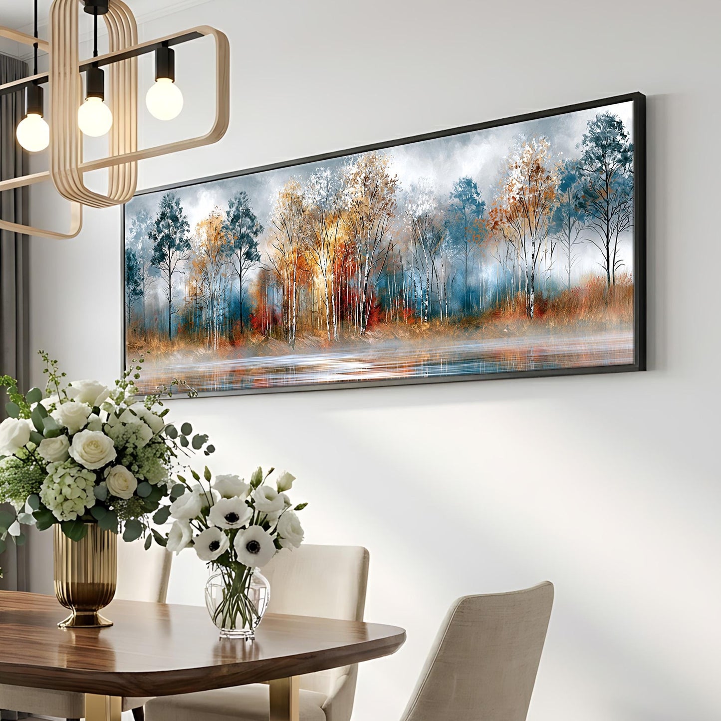 a dining room with a large painting of a forest scene hanging on the wall above a wooden table. The table is set with a vase of white flowers and a potted plant. The room has a modern and elegant design, with a chandelier and a white wall.